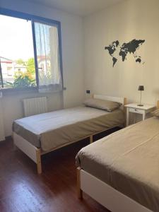 two beds in a room with a map on the wall at Como Gate - 10 minuti dal centro in Lucino