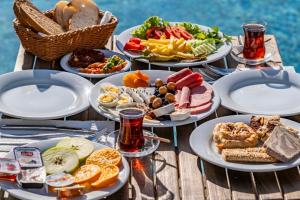 a table with plates of food on a table by the water at Costa Viva Bodrum in Bodrum City
