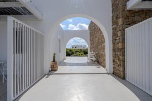 an arched hallway with a stone wall and an archway at Jo&Co Mykonos Nature Suites N3 in Plintri
