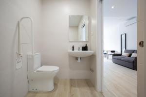 a white bathroom with a toilet and a sink at Urbil Puente Colgante in Portugalete +100 photos
