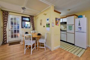 a kitchen with a table and chairs and a refrigerator at Finest Retreats - Delfryn in Talysarn