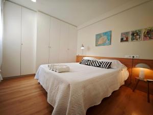 a bedroom with a large bed with white sheets at Vivienda Bendicho- CATEDRAL in Almería