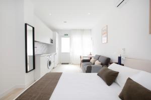 a white bedroom with a bed and a living room at Urbil Puente Colgante in Portugalete