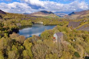 an old building in the middle of a lake at Finest Retreats - Delfryn in Talysarn