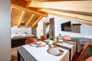 a dining room with a table and chairs and a bed at ChaletMafi in Valdidentro
