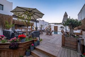 a wooden deck with a table and chairs and an umbrella at Costa Viva Bodrum in Bodrum City