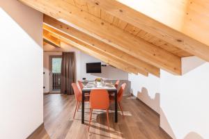 a dining room with a table and chairs under a wooden ceiling at ChaletMafi in Valdidentro