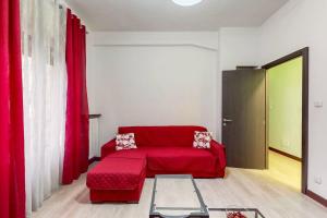 a living room with a red couch and red curtains at [AltaVista] Acqui sotto, cielo sopra il letto in Acqui Terme