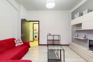 a living room with a red couch and a green door at [AltaVista] Acqui sotto, cielo sopra il letto in Acqui Terme +14 photos