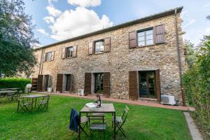 an external view of a stone house with tables and chairs at Residence La Casaccia in Venturina Terme