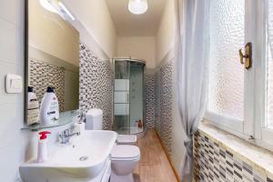 a bathroom with a sink and a toilet and a mirror at [AltaVista] Acqui sotto, cielo sopra il letto in Acqui Terme