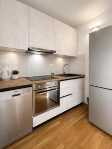 a kitchen with white cabinets and a stainless steel refrigerator at AAA Luxury Suites Split with Pool in Split