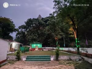a house with a green light in a yard at The Ghunadi Greens in Bāgeshwar