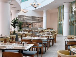 a restaurant with tables and chairs in a room at Imperial Island by Louis Hotels in Yeroskipou