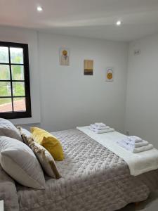 a bed in a white room with towels on it at El Encanto de Sixto in Santa Marta de Ortigueira
