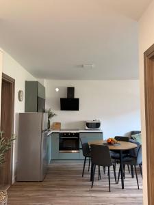 a kitchen and dining room with a table and a refrigerator at Apartman Andrea in Posušje