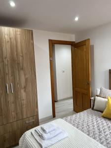 a bedroom with a bed and a wooden closet at El Encanto de Sixto in Santa Marta de Ortigueira