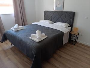 a bedroom with a large bed with towels on it at Apartman Andrea in Posušje