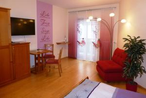 a living room with a red couch and a table at Lehnerhof in Grossraming