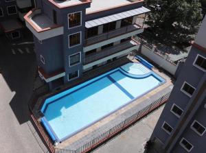 an overhead view of a swimming pool next to a building at MAIDA Apartment - SHAWMUT SUITES in Nakuru
