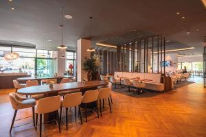 a restaurant with a long table and chairs at Van der Valk Hotel Spa in Spa