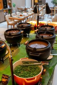 a table topped with pots and pans filled with food at Slaviero Prime Campo Grande in Campo Grande