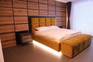 a bedroom with a large bed with a wooden wall at Rhein Suites in Eiken +14 photos