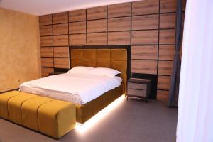 a bedroom with a large bed with a wooden wall at Rhein Suites in Eiken
