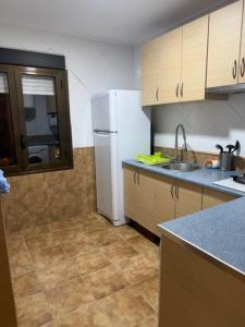 a kitchen with a white refrigerator and a sink at Mirador de los Tejados in Alcalá del Júcar +15 photos
