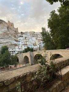 a bridge over a river with a city in the background at Mirador de los Tejados in Alcalá del Júcar