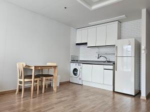 a kitchen with a table and a white refrigerator at Hongdae Penthouse in Seoul