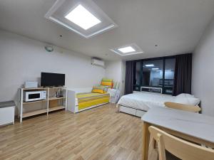 a bedroom with a bed and a tv and a table at Hongdae Penthouse in Seoul