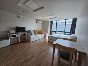 a room with a bed and a table and a couch at Hongdae Penthouse in Seoul