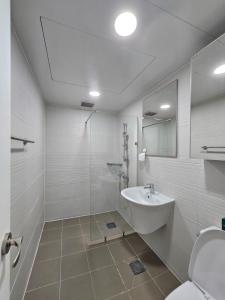 a white bathroom with a sink and a shower at Hongdae Penthouse in Seoul