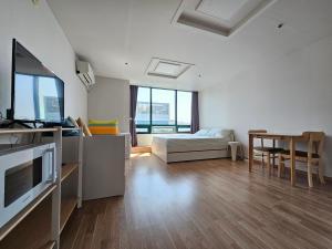 a large white room with a bed and a table at Hongdae Penthouse in Seoul