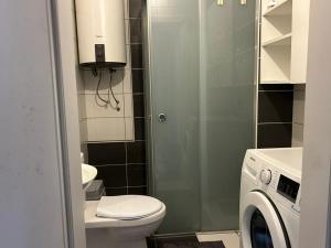 a bathroom with a toilet and a washing machine at Central apartment 4 in Gnjilane