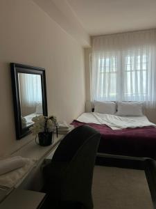 a bedroom with a large bed and a mirror at Central apartment 4 in Gnjilane