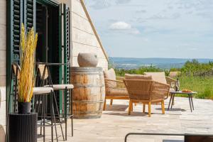 a patio with a table and chairs and a barrel at KisEtyek Vendégház in Etyek