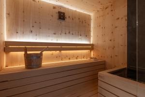 a wooden sauna with a bucket in it at Hotel alle Rose Family inspired garden and SPA in Cavedago