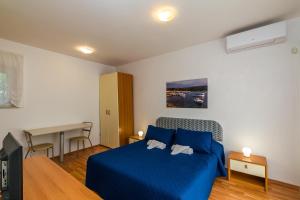 a bedroom with a blue bed and a desk at Sun Palace Residence in Premantura +50 photos