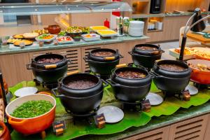 a buffet with many pots of food on a counter at Slaviero Prime Campo Grande in Campo Grande