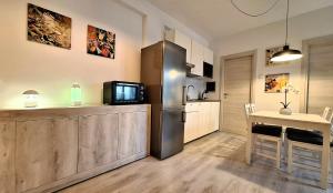 a kitchen with a refrigerator and a table with a television at Al Glicine Apartments in Lazise +86 photos