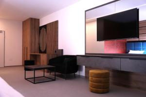 a hotel room with a tv and a chair and a table at Rhein Suites in Eiken