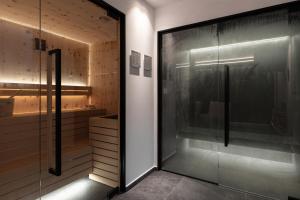 a shower with a glass door in a bathroom at Hotel alle Rose Family inspired garden and SPA in Cavedago