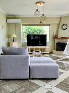 a living room with a couch and a tv at Christina's Cottage in Agios Nikolaos