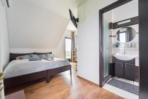 a bedroom with a bed and a sink and a mirror at KisEtyek Vendégház in Etyek