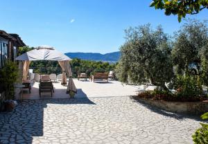 a patio with tables and chairs and an umbrella at Fattoria Cristina Family Duplex with Pool, Panoramic Terrace & Farm Animals - Bilo Rosa in Castelnuovo Magra