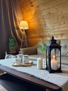 a coffee table with a lantern and candles on it at Chalet Adjara in Okʼropilauri