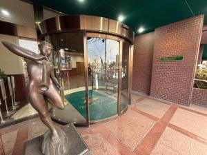 a statue of a girl with a surfboard in a building at HOTEL Dane&Kerry DogResort in Ishioka
