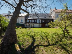 a house and a tree in a yard at Chalupa Domovina in Jiřetín pod Jedlovou